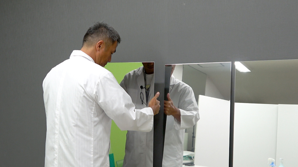 ガラスと金属のミラーを触る様子