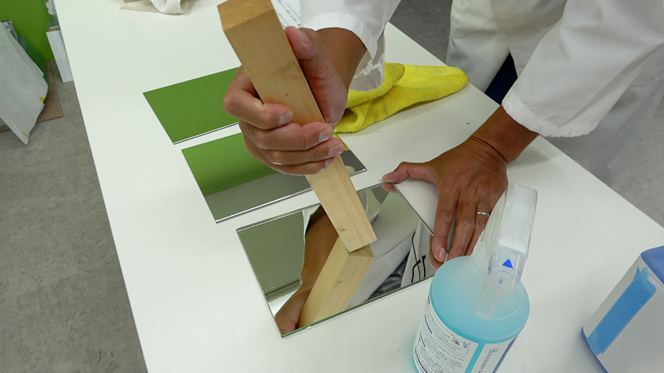 木材で鏡を擦る様子